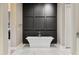 Contemporary bathroom featuring a freestanding bathtub against a modern wall panel, and sleek marble floors at 2 Biltmore Est # 309, Phoenix, AZ 85016