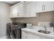 Well-organized laundry room with modern appliances, marble countertops, and ample cabinet space at 2 Biltmore Est # 309, Phoenix, AZ 85016