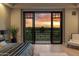 Bedroom featuring a scenic view through large sliding glass doors overlooking the lush greenery during sunset at 2 Biltmore Est # 309, Phoenix, AZ 85016