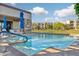 Community pool with inviting blue water, umbrellas, and comfortable lounge chairs at 2 Biltmore Est # 309, Phoenix, AZ 85016