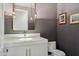 Elegant powder room featuring designer mirror and lighting, white vanity, and striking wall coverings at 2 Biltmore Est # 309, Phoenix, AZ 85016