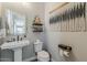Cozy powder room featuring a classic pedestal sink and decorative wall hangings, adding a touch of charm and elegance at 2024 W Trotter Trl, Phoenix, AZ 85085