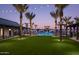 Community pool area at dusk featuring palm trees, lounge chairs, and string lights at 2024 W Trotter Trl, Phoenix, AZ 85085