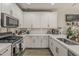 Stylish kitchen featuring white cabinets, stainless steel appliances, and chic backsplash, offering both functionality and modern design at 2024 W Trotter Trl, Phoenix, AZ 85085