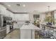 Bright kitchen with white cabinetry, quartz countertops, stainless steel appliances, and eat-in island at 2024 W Trotter Trl, Phoenix, AZ 85085