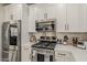 Well-equipped kitchen boasting stainless steel appliances, white cabinetry, and elegant backsplash, blending convenience and style at 2024 W Trotter Trl, Phoenix, AZ 85085