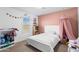 Cozy bedroom featuring a white bed frame, pink accent wall, and charming decor at 21288 E Via Del Sol --, Queen Creek, AZ 85142