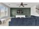 Comfortable living room featuring a dark accent wall, floating shelves, and ample natural light at 21288 E Via Del Sol --, Queen Creek, AZ 85142
