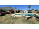 A backyard with a swimming pool, shed, lush greenery, and a bench creates an inviting outdoor living space at 2137 W Del Campo Cir, Mesa, AZ 85202