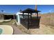 View of the backyard features a custom structure and storage shed nestled against a block wall under a blue sky at 2137 W Del Campo Cir, Mesa, AZ 85202