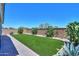 Lush backyard featuring artificial turf, a brick wall, and desert landscaping for easy maintenance at 21595 S 225Th Way, Queen Creek, AZ 85142