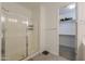 Modern bathroom with glass shower, neutral tile, and walk-in closet in a well-lit space at 21595 S 225Th Way, Queen Creek, AZ 85142