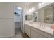 Bright bathroom featuring double sinks, walk-in closet, neutral tile floors, and modern fixtures at 21595 S 225Th Way, Queen Creek, AZ 85142