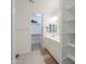 Bright bathroom featuring double sinks, walk-in closet, neutral tile floors, and built-in shelves at 21595 S 225Th Way, Queen Creek, AZ 85142