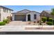 Front view of home features desert landscaping, attached garage, and a charming, covered entry at 21595 S 225Th Way, Queen Creek, AZ 85142
