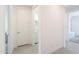 Hallway to laundry room with white door, white walls, and neutral floors at 21595 S 225Th Way, Queen Creek, AZ 85142