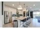 Kitchen island features a granite countertop, modern lighting, and stainless steel appliances at 21595 S 225Th Way, Queen Creek, AZ 85142