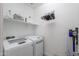 Clean laundry room features white appliances, storage shelves, and useful accessories at 21595 S 225Th Way, Queen Creek, AZ 85142
