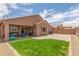 This backyard has a grass area, covered patio, and a brick paver patio for entertaining at 21950 N Dietz Dr, Maricopa, AZ 85138