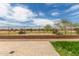 View of backyard with pavers, view fencing and golf course in the distance, under a sunny, partly cloudy sky at 21950 N Dietz Dr, Maricopa, AZ 85138