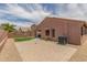 This backyard has a grass area, covered patio, and a brick paver patio for entertaining at 21950 N Dietz Dr, Maricopa, AZ 85138