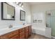 Bright bathroom features double sinks, wood cabinets, tiled floors, bathtub, and glass shower at 21950 N Dietz Dr, Maricopa, AZ 85138