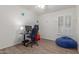 Bedroom features tile floors, neutral walls, window with blinds, and black desk at 21950 N Dietz Dr, Maricopa, AZ 85138
