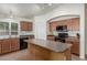 Modern eat-in kitchen with large center island, black appliances, tile floors, and ample counter space at 21950 N Dietz Dr, Maricopa, AZ 85138