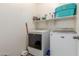 This laundry room features a washer and dryer, shelving, and storage space at 21950 N Dietz Dr, Maricopa, AZ 85138