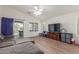 Bright living room with wood-look tile flooring and a sliding glass door leading to the backyard patio at 21950 N Dietz Dr, Maricopa, AZ 85138