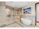 Elegant bathroom featuring a freestanding tub and a walk-in shower with bench seating at 2211 E Camelback Rd # 1203, Phoenix, AZ 85016