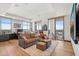 Spacious living room with hardwood floors, large windows, and access to an outdoor balcony at 2211 E Camelback Rd # 1203, Phoenix, AZ 85016