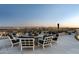 Rooftop patio with comfortable seating and a fire pit, set against a backdrop of city lights at dusk at 2211 E Camelback Rd # 1203, Phoenix, AZ 85016