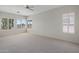 Spacious bedroom featuring neutral carpet, light walls, bright windows, and a ceiling fan at 22231 N 51St St, Phoenix, AZ 85054