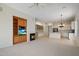 Open-concept living room with fireplace, media center, carpet, and view of the kitchen with center island at 22231 N 51St St, Phoenix, AZ 85054