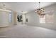 Welcoming living room featuring large windows with bright natural light, chandelier, and tiled flooring at entry at 22231 N 51St St, Phoenix, AZ 85054