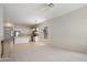 Open-concept living room showcasing neutral carpet, chandelier and kitchen with center island and stainless fridge at 22231 N 51St St, Phoenix, AZ 85054