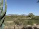 Scenic golf course view framed by a metal fence and desert landscape, mountains visible in the background at 22231 N 51St St, Phoenix, AZ 85054