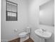 Simple half bath featuring a pedestal sink, toilet, and window with privacy blinds at 23451 S 228Th St, Queen Creek, AZ 85142