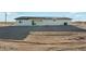 Home exterior featuring a covered patio in a dirt lot. The yard is barren, offering a blank canvas for landscaping at 22387 S Manzanilla Rd, Buckeye, AZ 85326