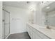 Bathroom featuring dual sinks, a wide vanity, and a glass-door shower at 22387 S Manzanilla Rd, Buckeye, AZ 85326