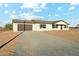 Single-story home with a two-car garage, gravel driveway, and neutral exterior at 22387 S Manzanilla Rd, Buckeye, AZ 85326