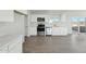 Modern kitchen with stainless steel appliances, white cabinetry and hard wood flooring at 22387 S Manzanilla Rd, Buckeye, AZ 85326