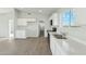 Modern kitchen featuring hard wood flooring, white cabinetry, and stainless steel appliances at 22387 S Manzanilla Rd, Buckeye, AZ 85326