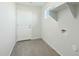 Bright laundry room with wood-look tile flooring, utility connections, and overhead storage at 22387 S Manzanilla Rd, Buckeye, AZ 85326