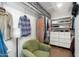 A very spacious closet includes shelving and drawers with a cozy green chair at 2300 E Campbell Ave # 104, Phoenix, AZ 85016