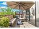 Cozy outdoor patio features cushioned seating, a large umbrella, and lush greenery, perfect for relaxation at 2300 E Campbell Ave # 104, Phoenix, AZ 85016