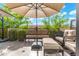 Relaxing patio with comfortable seating, an umbrella, and lush landscaping, perfect for enjoying the outdoors at 2300 E Campbell Ave # 104, Phoenix, AZ 85016