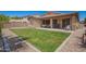 Lush backyard with grass, rocks, and patio with outdoor furniture for relaxing entertainment at 233 W Sweet Shrub Ave, San Tan Valley, AZ 85140