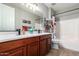 Bathroom with double sink vanity, large mirror, and bathtub with shower at 233 W Sweet Shrub Ave, San Tan Valley, AZ 85140